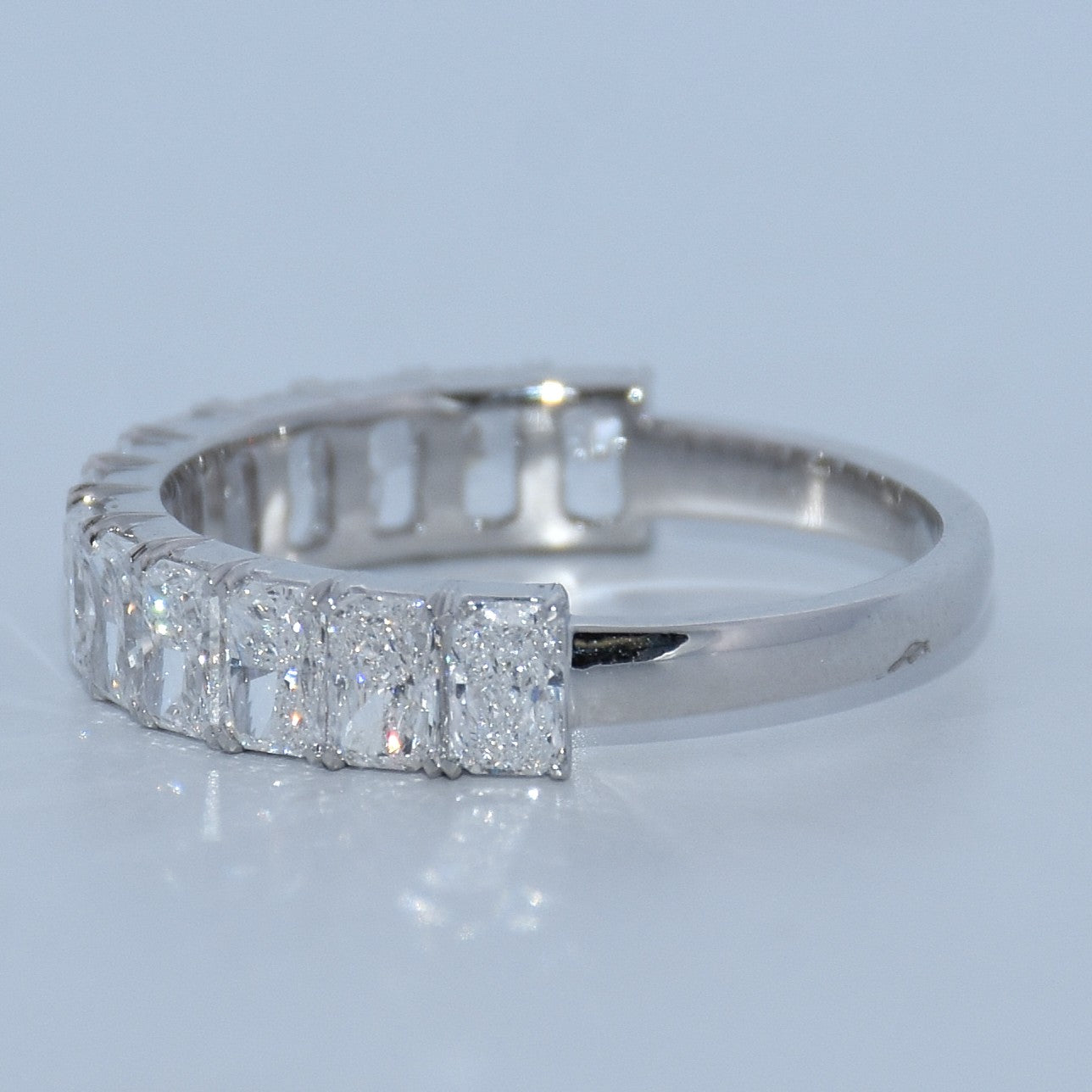 1.94-carat radiant-cut emerald centerpiece complemented by lab-grown diamond