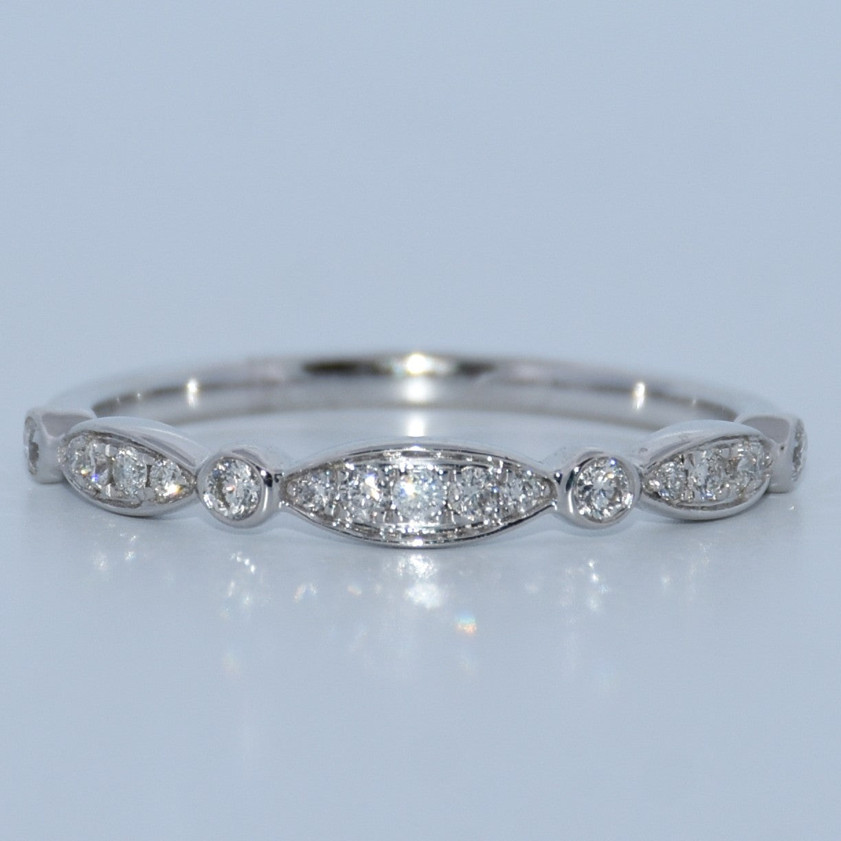 WG ring with diamond stones on a light gray background