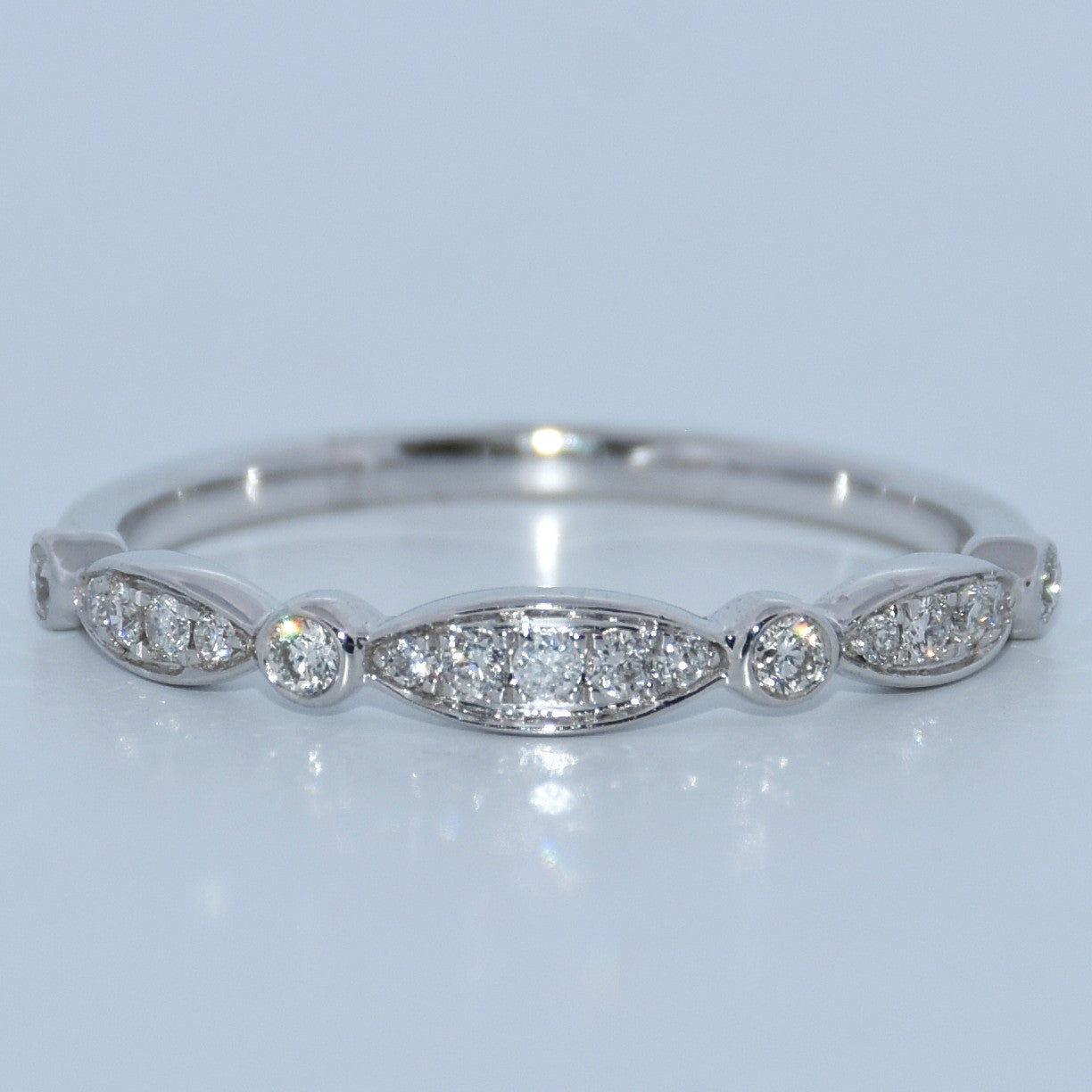WG ring with diamond accents on a light gray background