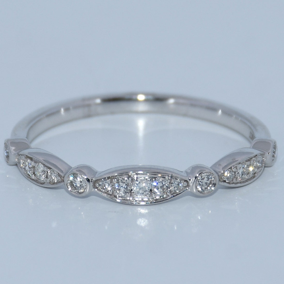 Silver ring with diamond stones on a light gray background