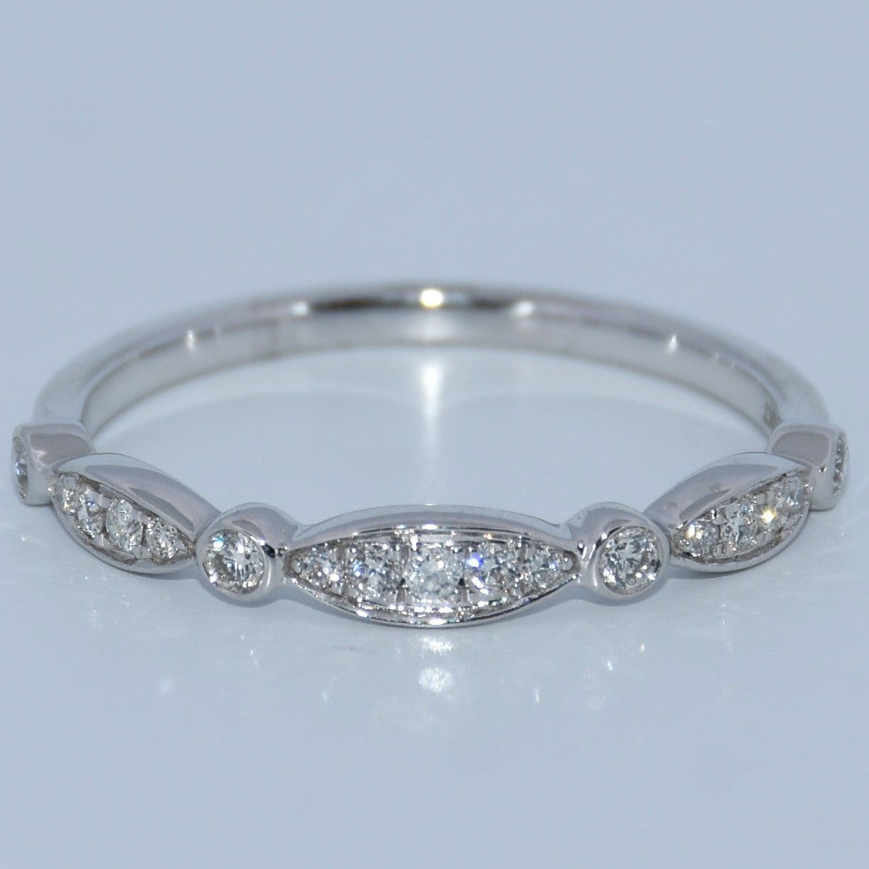 Silver ring with diamond stones on a light gray background