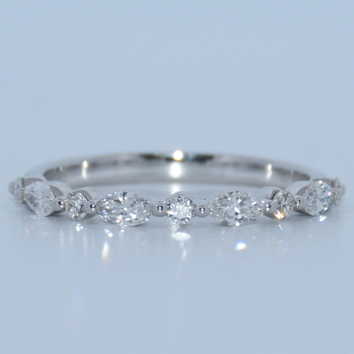Silver ring with diamond stones on a light gray background