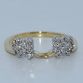 Gold ring with diamond clusters on a light gray background