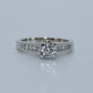 Diamond ring with a white gold band on a light gray background