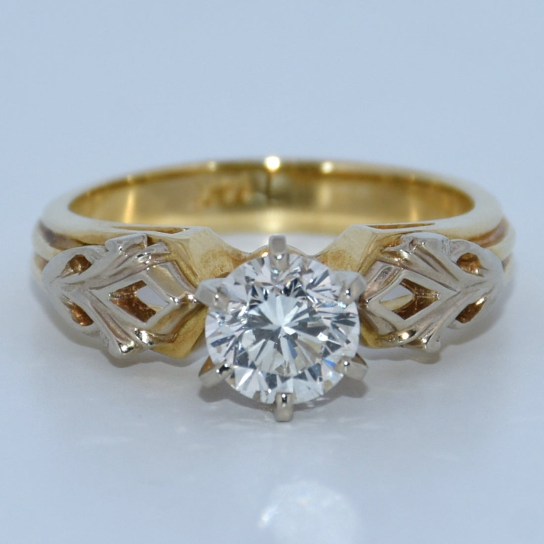 Gold ring with a diamond on a white background