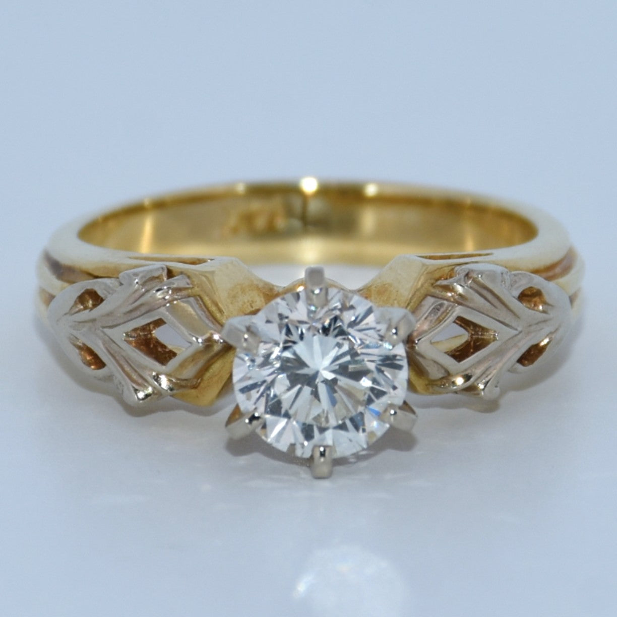 Gold ring with a diamond on a white background
