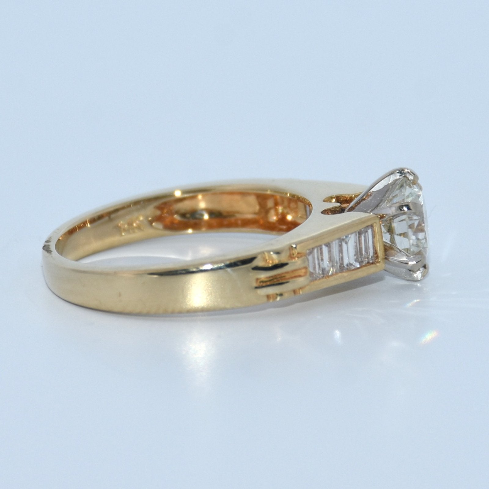 Gold ring with a diamond on a light blue background