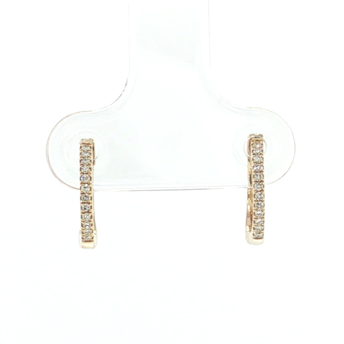 A pair of small gold huggie hoop earrings with a row of clear stones, displayed on a clear plastic jewelry stand against a white background.