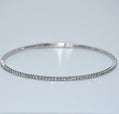 Silver bracelet with small stones on a light gray background