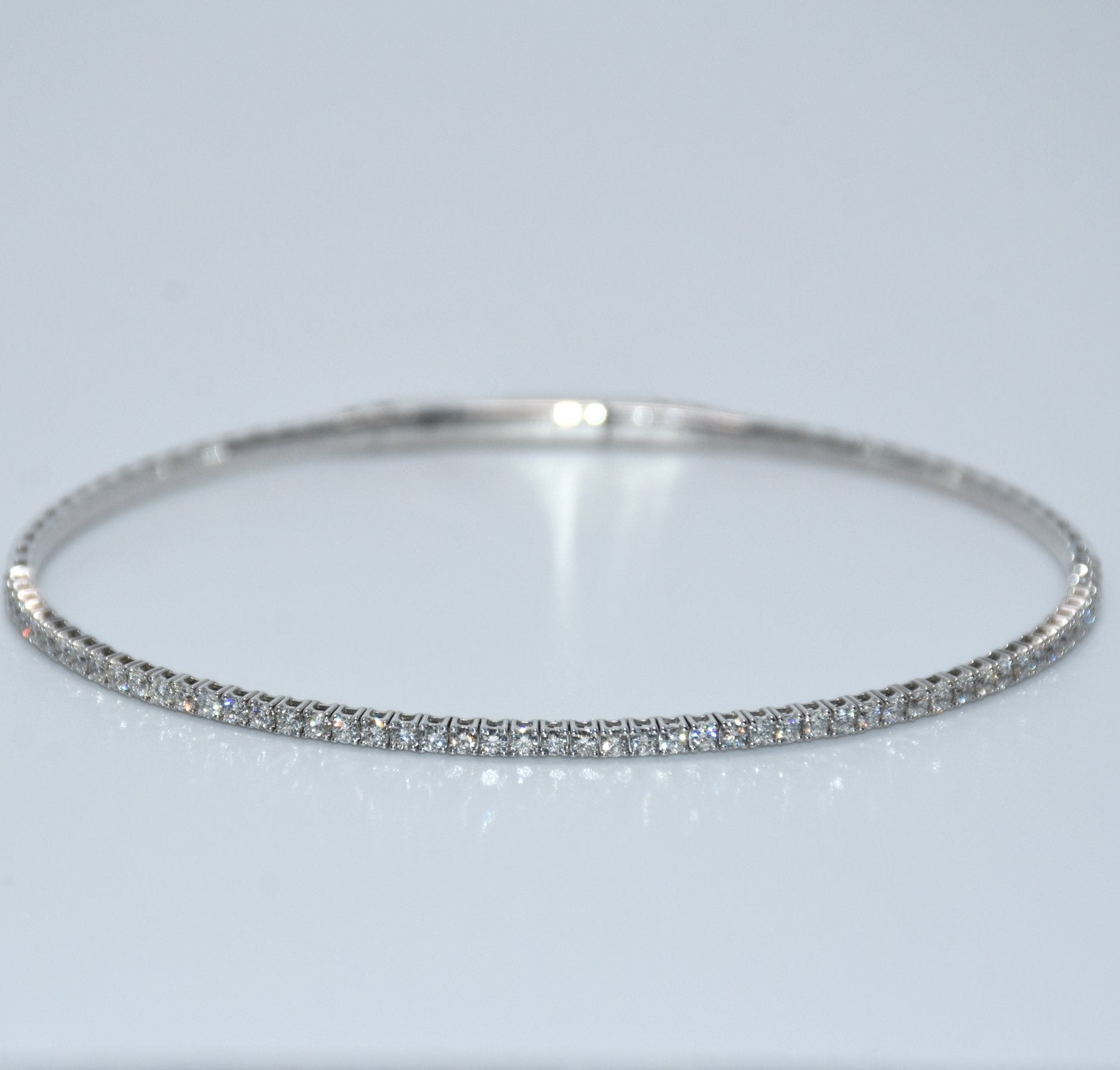 Silver bracelet with small stones on a light gray background