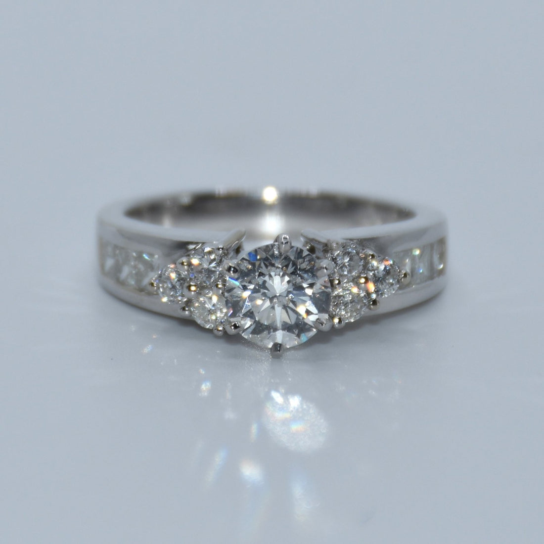 Silver ring with multiple diamonds on a light gray background