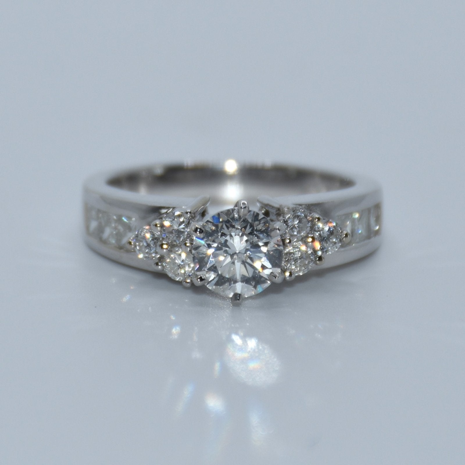Silver ring with multiple diamonds on a light gray background