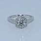 Diamond ring with a hexagonal halo on a light gray background
