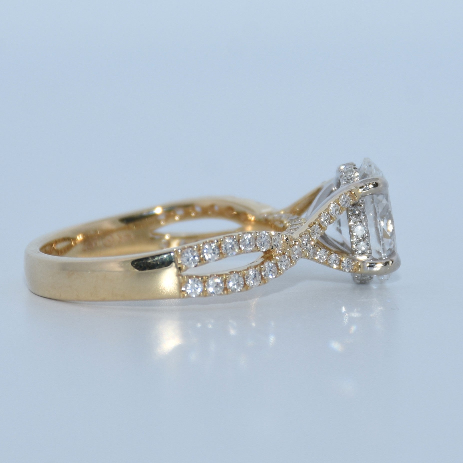 Gold ring with diamond accents on a light gray background