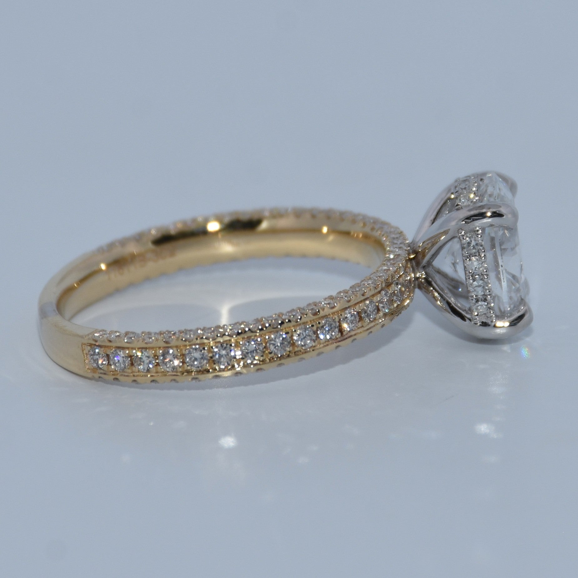 Gold ring with diamond accents on a light gray background