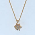Gold necklace with a star-shaped pendant on a light blue background