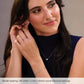 Woman wearing 14K white gold round diamond earrings with a neutral background