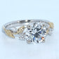 Diamond ring with gold leaf designs on a light blue background