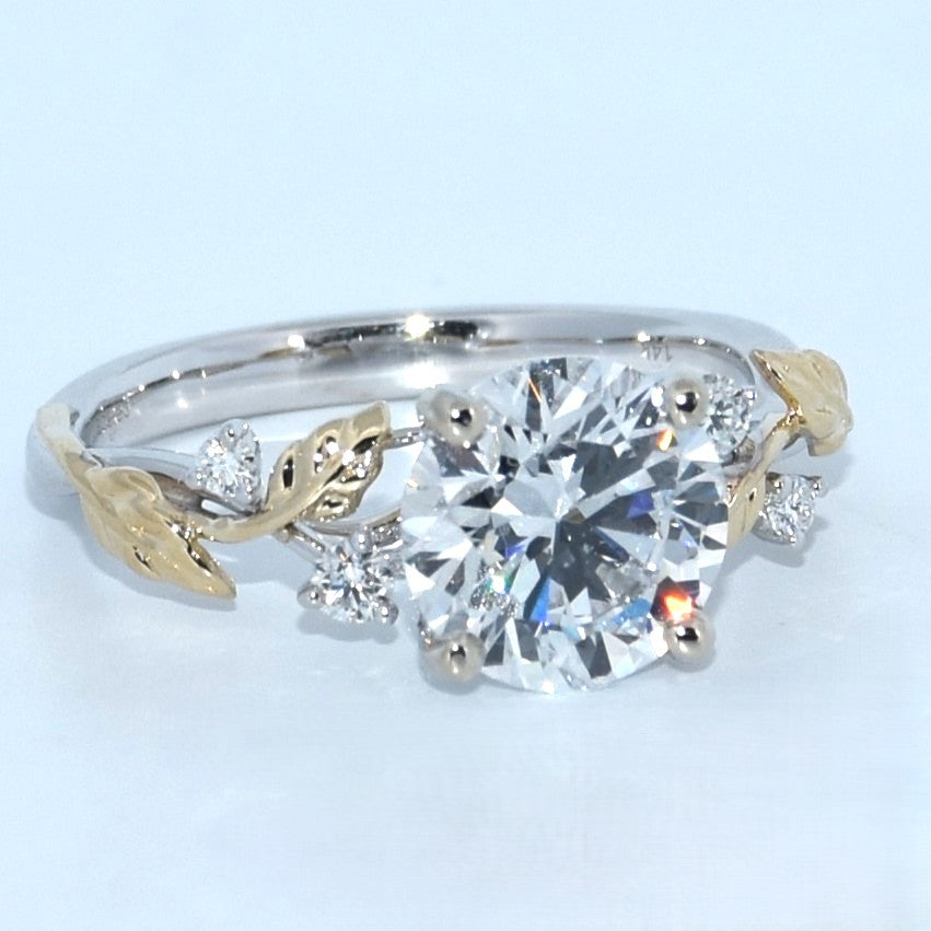 Diamond ring with gold leaf designs on a light blue background