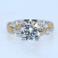Diamond ring with gold leaf designs on a light gray background