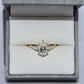 Gold ring with a diamond in a jewelry box on a light gray background