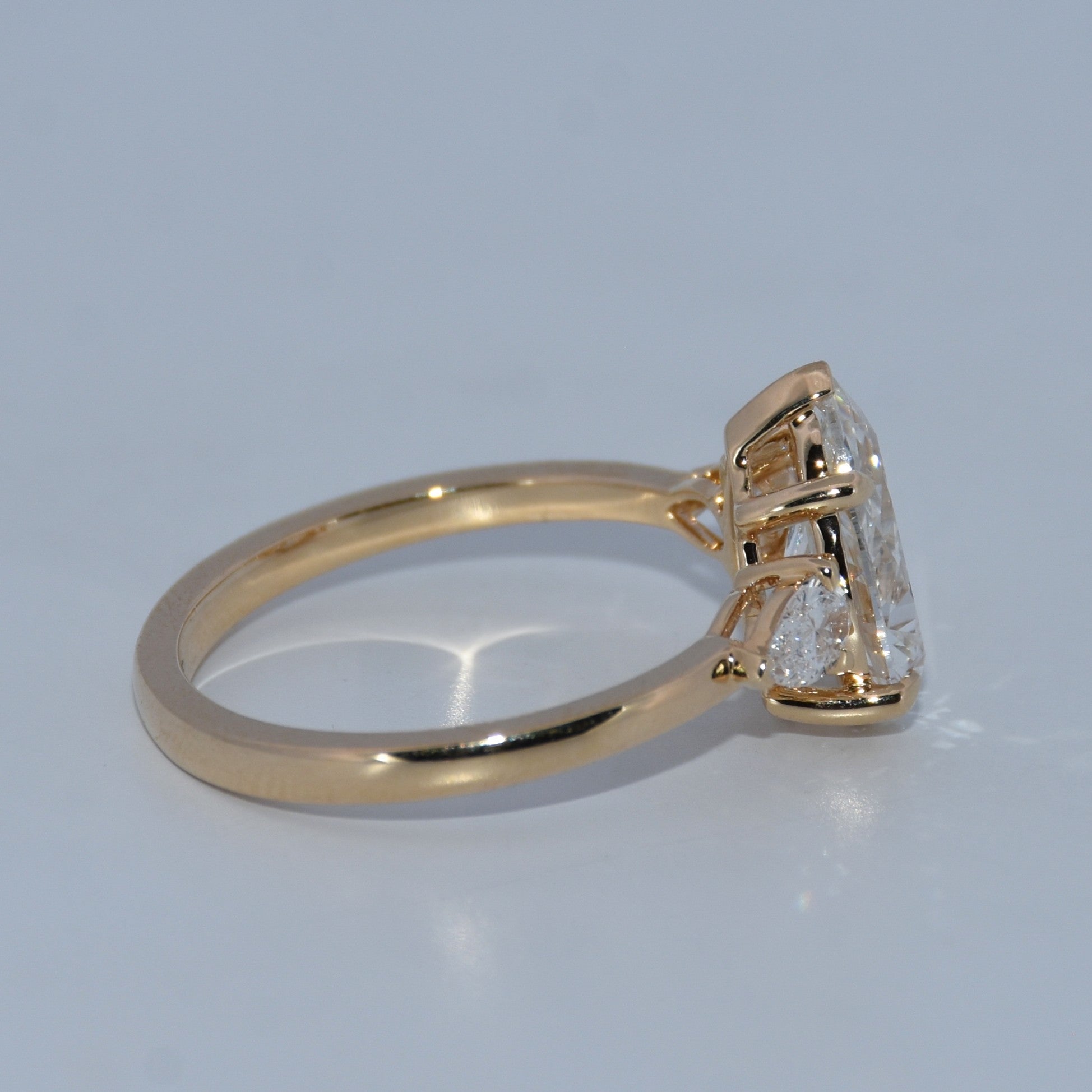 Gold ring with a diamond on a light gray background