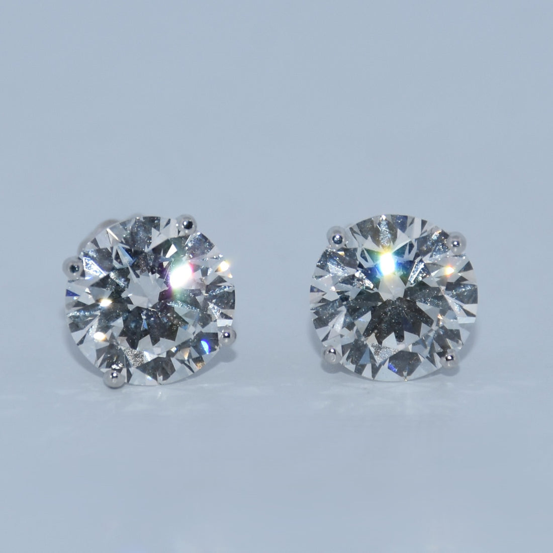 Pair of diamond stud earrings on a light gray background
