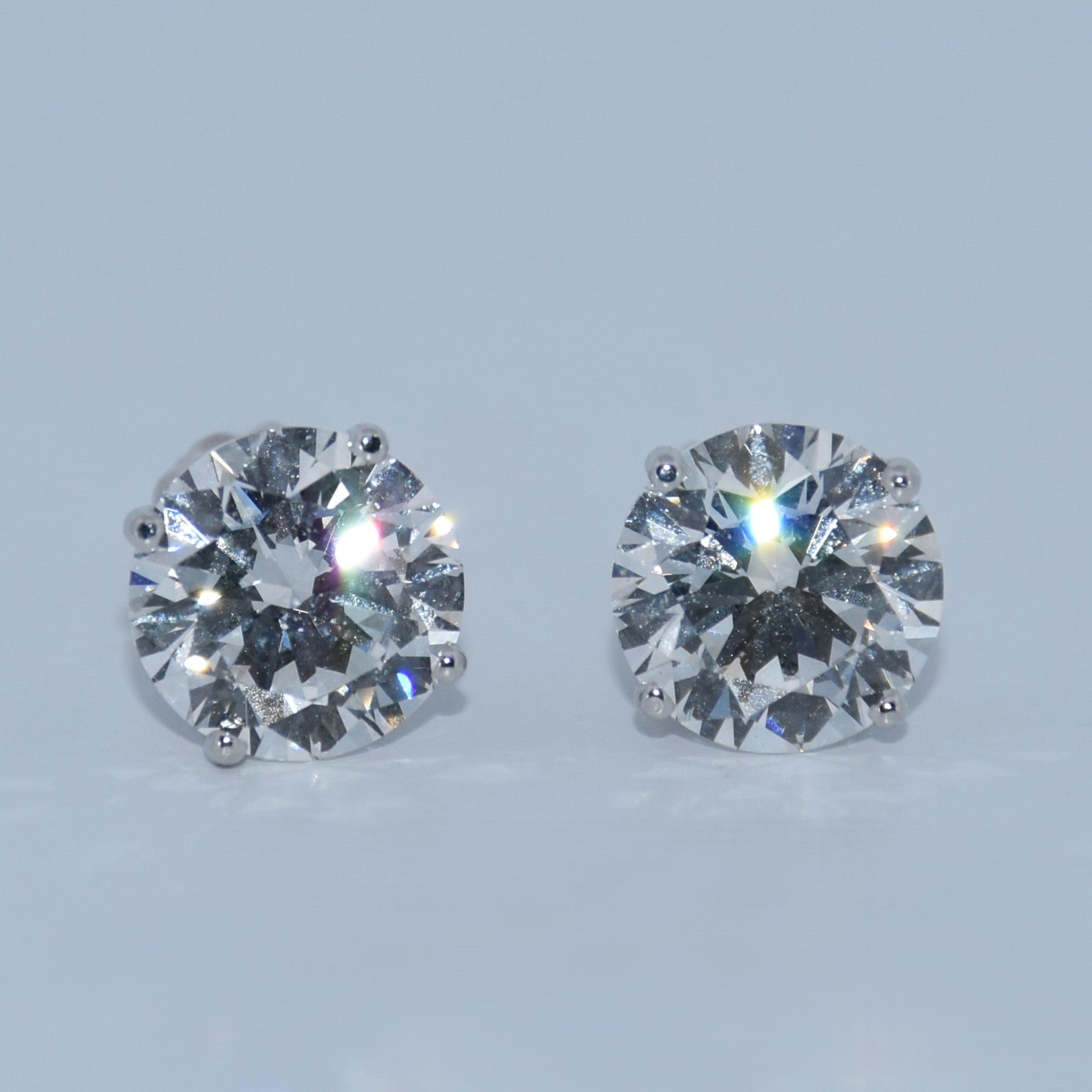 Pair of diamond stud earrings on a light gray background