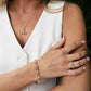 Close-up of a woman wearing gold jewelry including a necklace, bracelet, and ring. 14K Gold| Celtic Eternity Band with Lab Diamonds