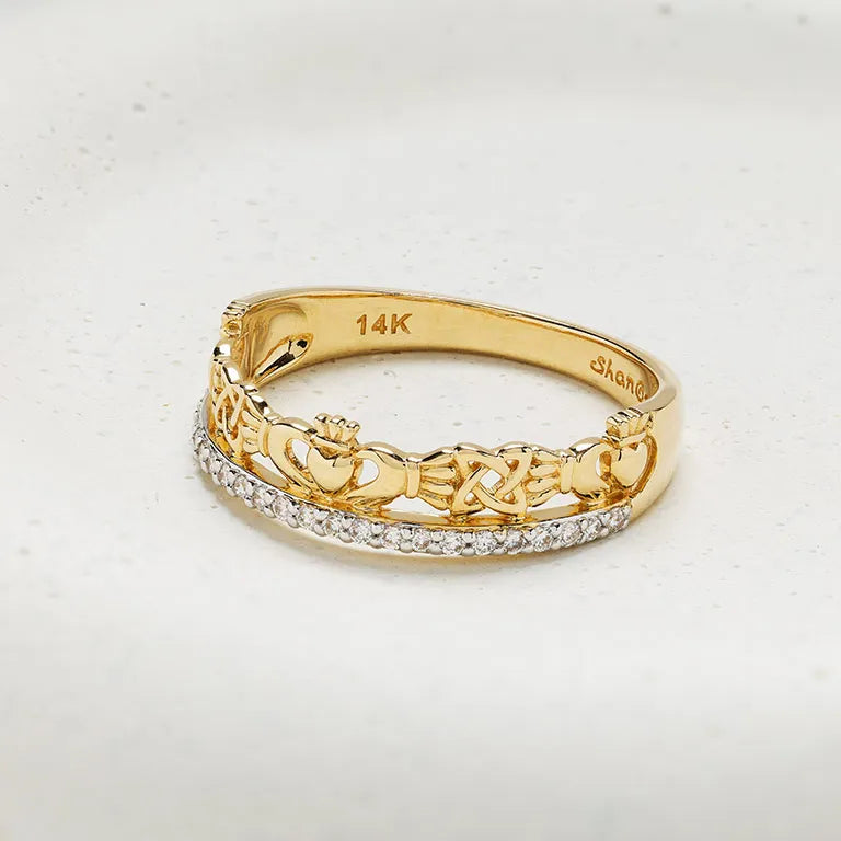 A yellow gold Irish ring featuring a continuous band of cut claddagh links and hearts, with a single row of small clear pavé stones along the front. The inner band is stamped with '14K' and 'Shannon'. 14K Gold | Claddagh Ring with Lab Diamonds Border