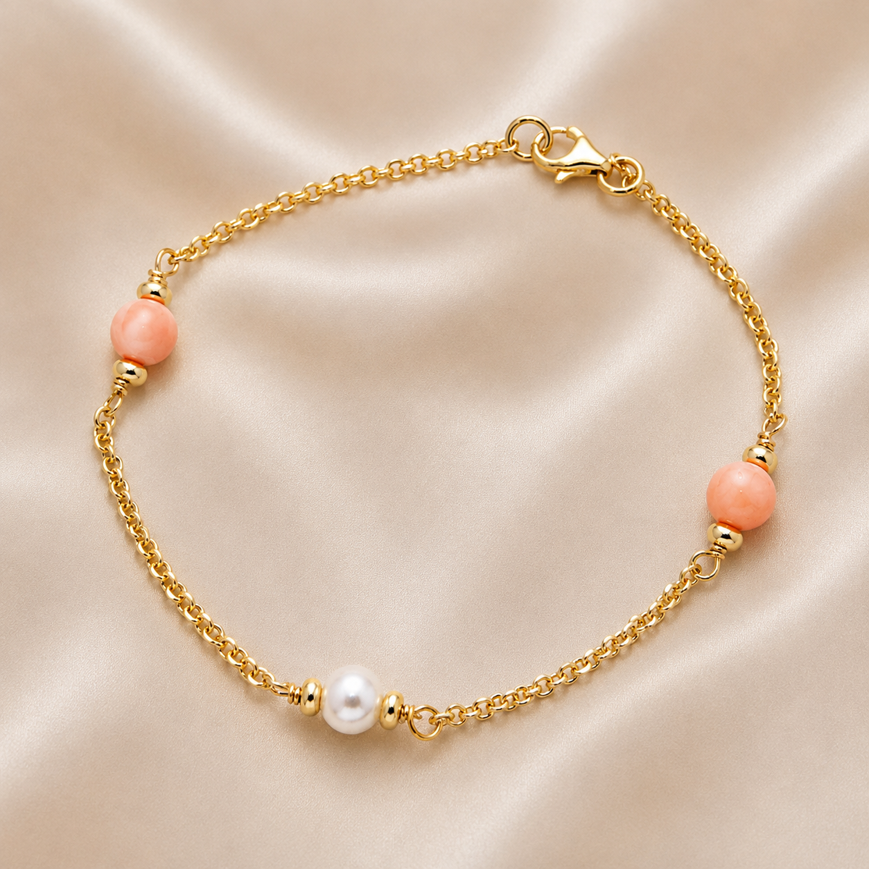 Gold bracelet with pink beads on a beige fabric background 14K Gold | Pink & White Pearl Bracelet
