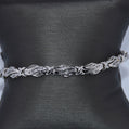 Silver belt with leaf-like design on a black mannequin