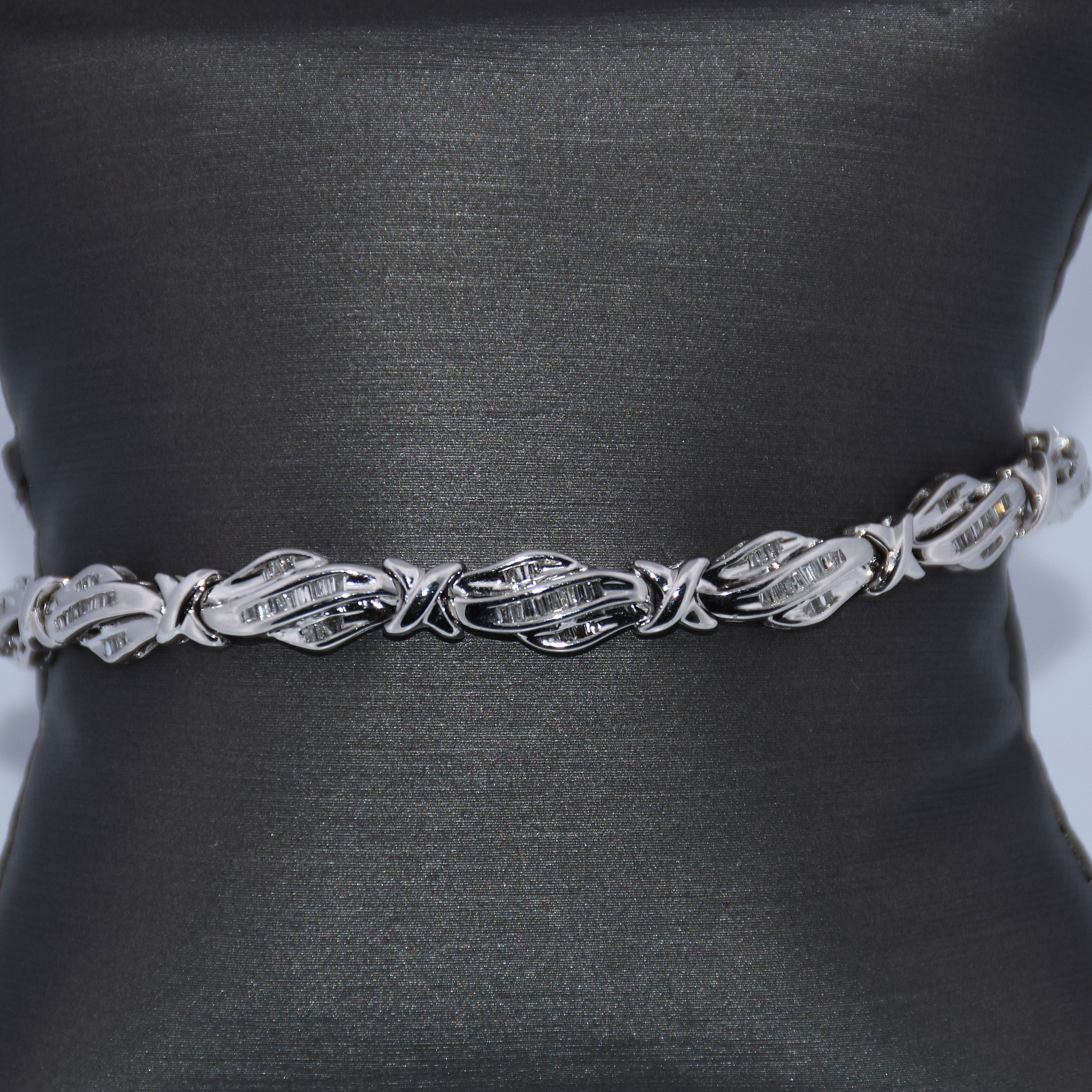Silver belt with leaf-like design on a black mannequin