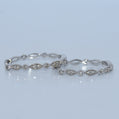 Silver bracelet with diamond accents on a light gray background