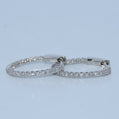 Pair of silver hoop earrings on a light blue background