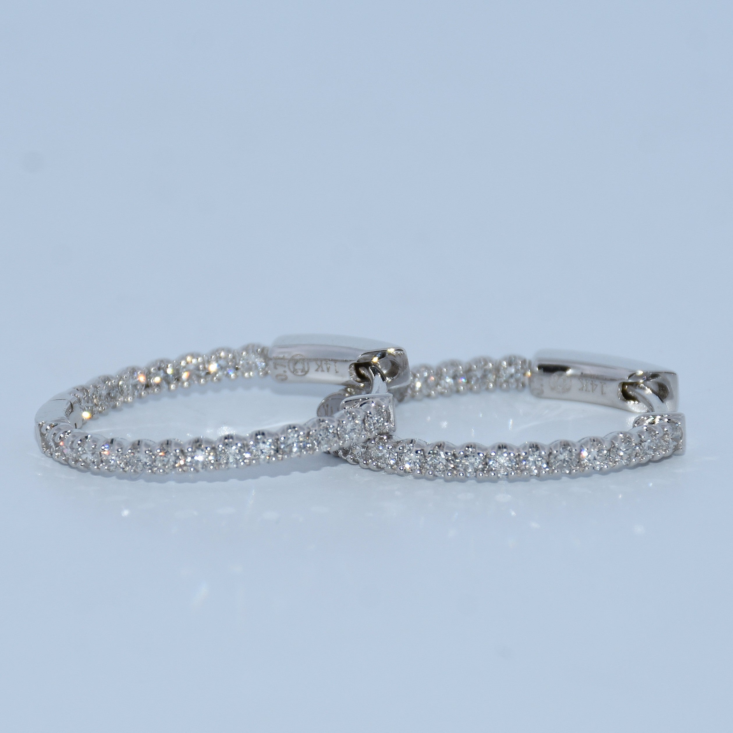 Pair of silver hoop earrings on a light blue background