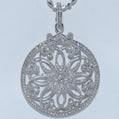 Silver floral pendant with clear stones on a light gray background