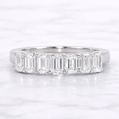 Diamond ring with baguette-cut stones on a white background