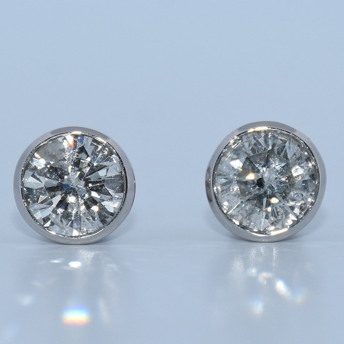 Pair of diamond stud earrings on a light gray background