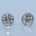 Pair of diamond stud earrings on a light gray background