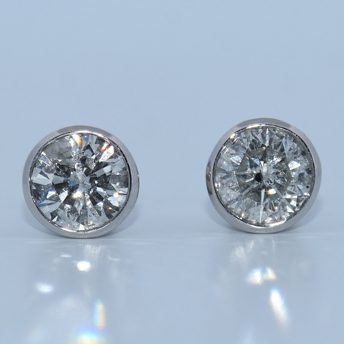 Pair of diamond stud earrings on a light gray background