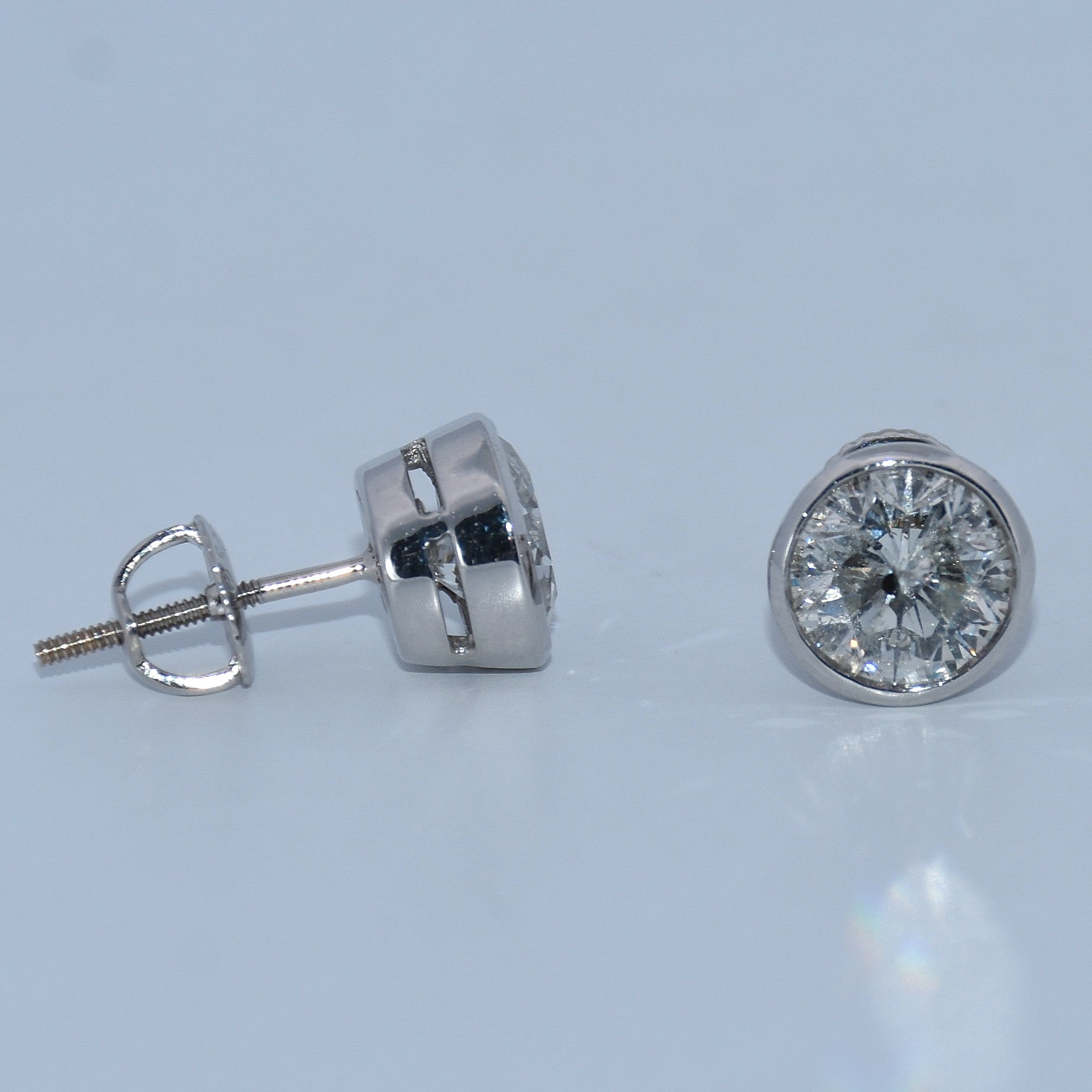 Pair of diamond stud earrings on a light blue background