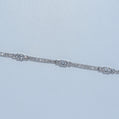 Silver bracelet with clear stones on a light blue background