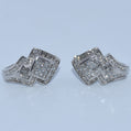 Pair of silver square-shaped earrings with clear stones on a light blue background