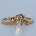Gold ring with diamond accents on a light gray background