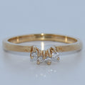 Gold ring with diamond accents on a light gray background