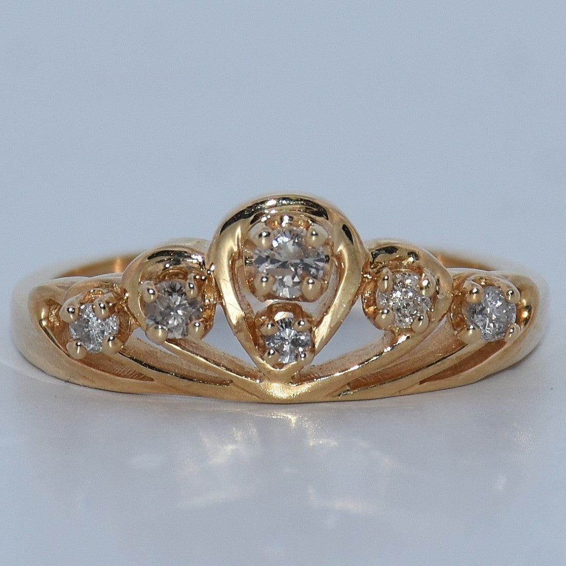 Gold ring with diamond accents on a light gray background