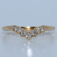 Gold ring with diamonds on a light gray background