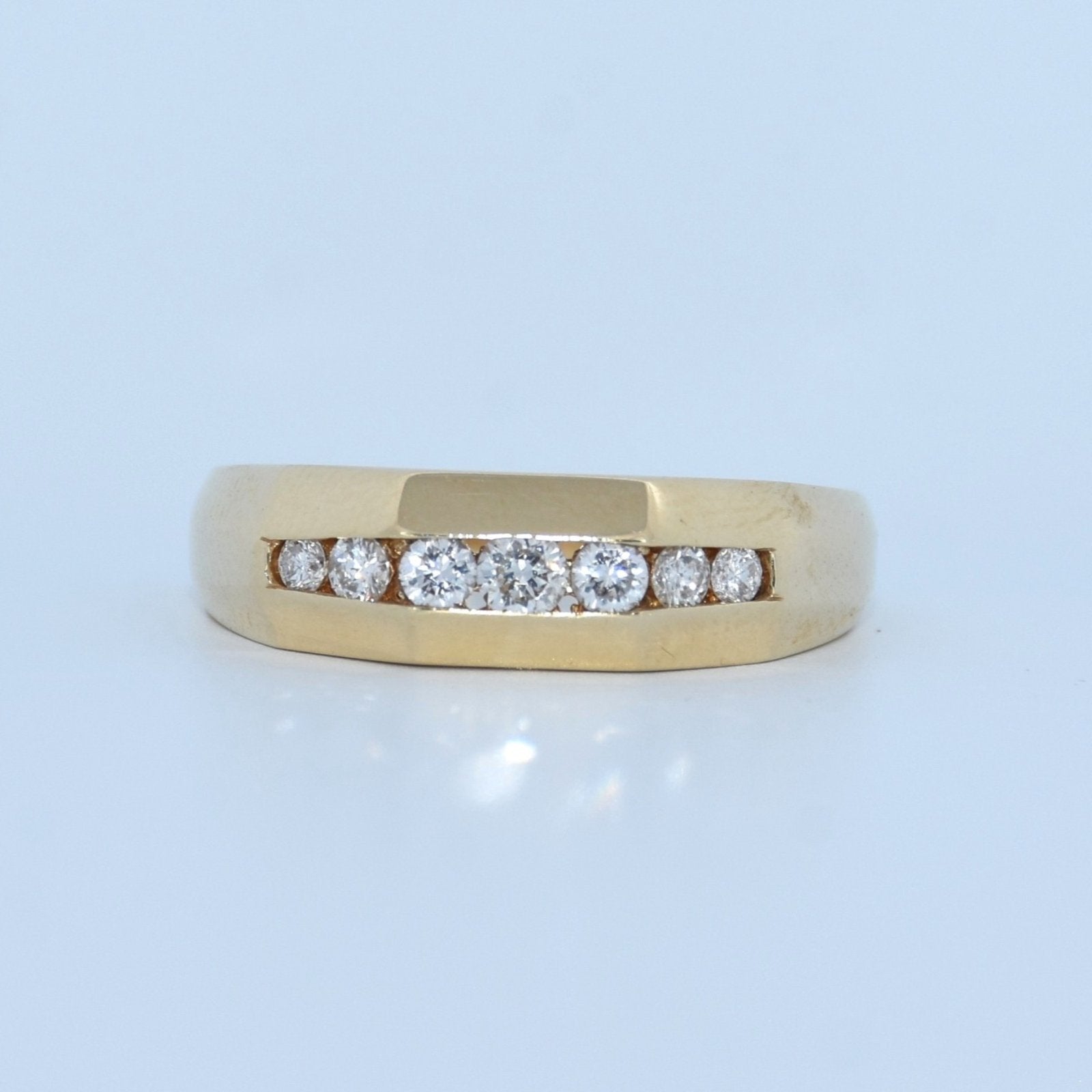 Gold ring with diamonds on a light blue background