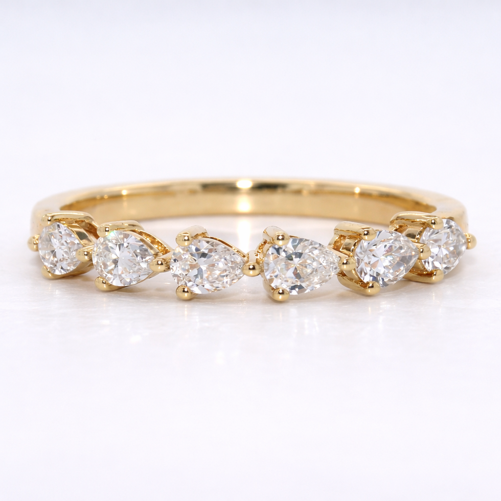 Gold ring with pear-shaped diamonds on a white background